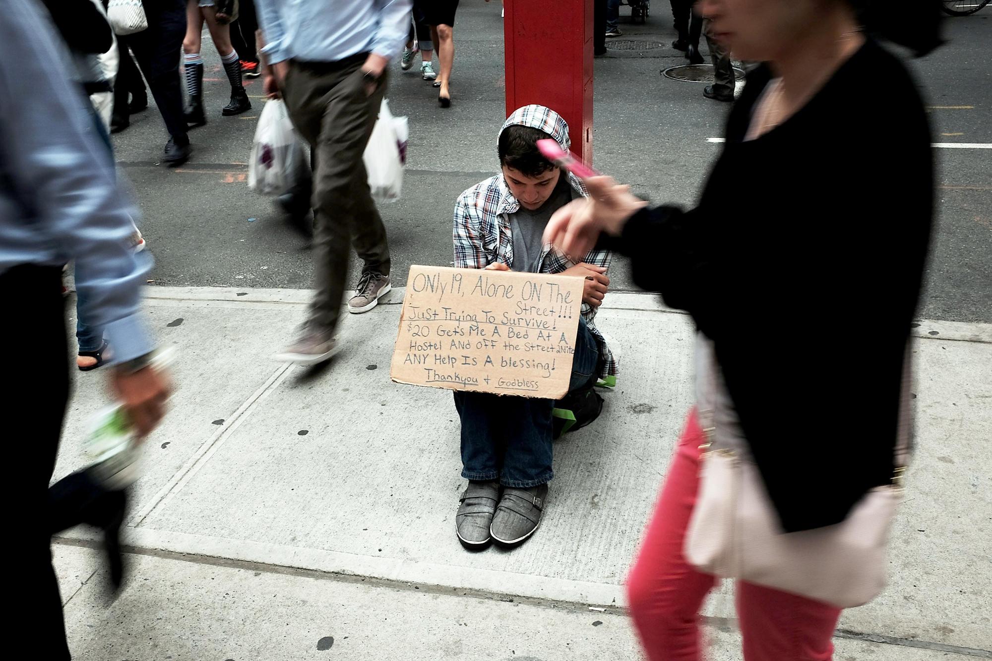 A homeless teen panhandles on a street near Eighth Avenue in Manhattan on May 18, 2015 in New York City. As many parts of once seedy New York City have been transformed into family and shopping friendly environments, 8th Avenue near the Port Authority bus station is one of the last hold-outs to old gritty Manhattan. Last week a man was shot by police after he attacked numerous people with a hammer along a stretch of the street. There is a high police presence along the street and fights and arrests for vagrancy are common. (Spencer Platt/Getty Images/TNS)
