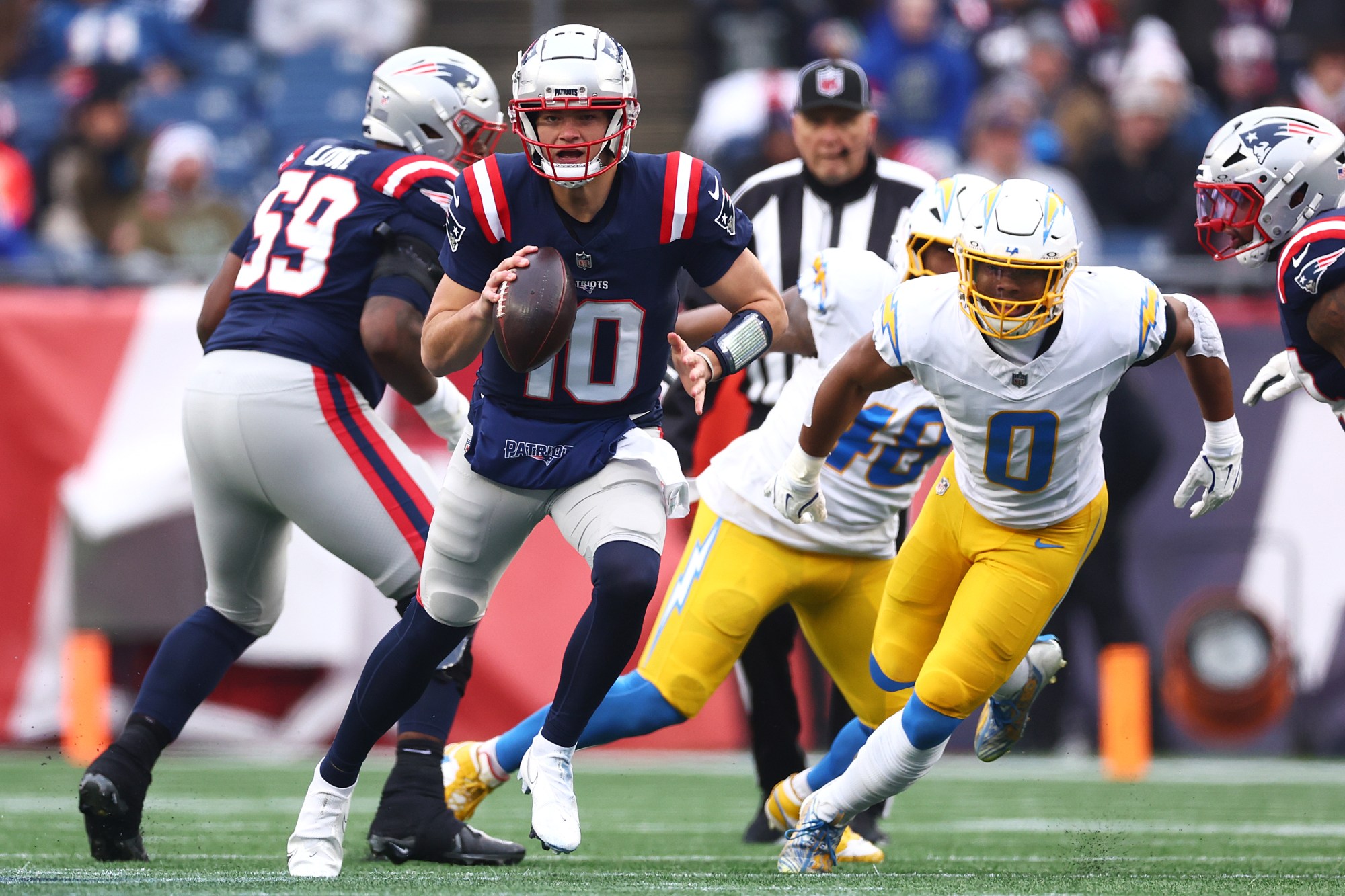 New England Patriots quarterback Drake Maye scrambles up the field as Chargers linebacker Daiyan Henley (0) chases him during their Dec. 2024 game in Foxborough, Mass. The Chargers will try to limit Maye, who has evolved into a league MVP candidate in his second NFL season, when the teams square off in an AFC wild-card playoff game on Sunday night in Foxboro. (Photo by Maddie Meyer/Getty Images)

